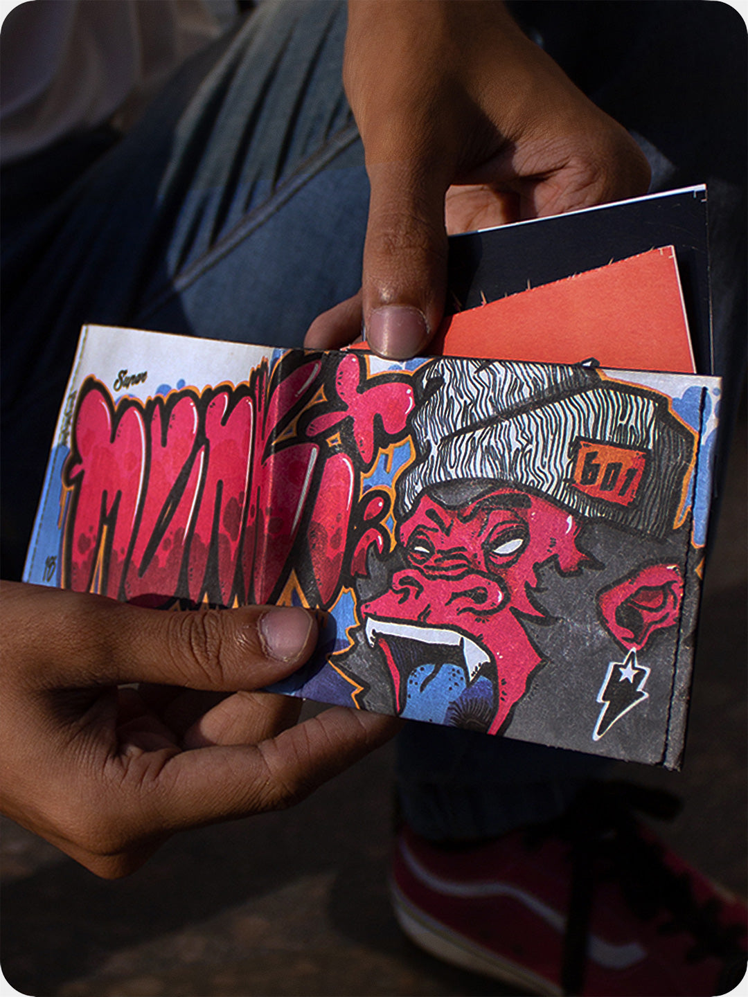 Supervek Tyvek wallet with "Munki" street-art design held in hand, bold graphic vegan billfold with slim profile