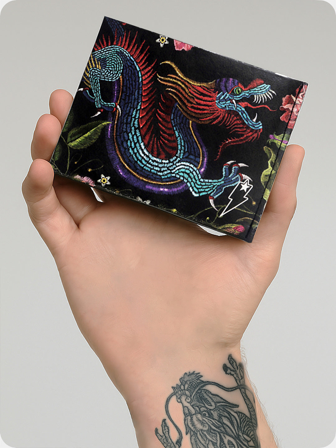 Supervek Tyvek wallet with "Oriental Dragon" design, slim black vegan billfold, held in tattooed hand
