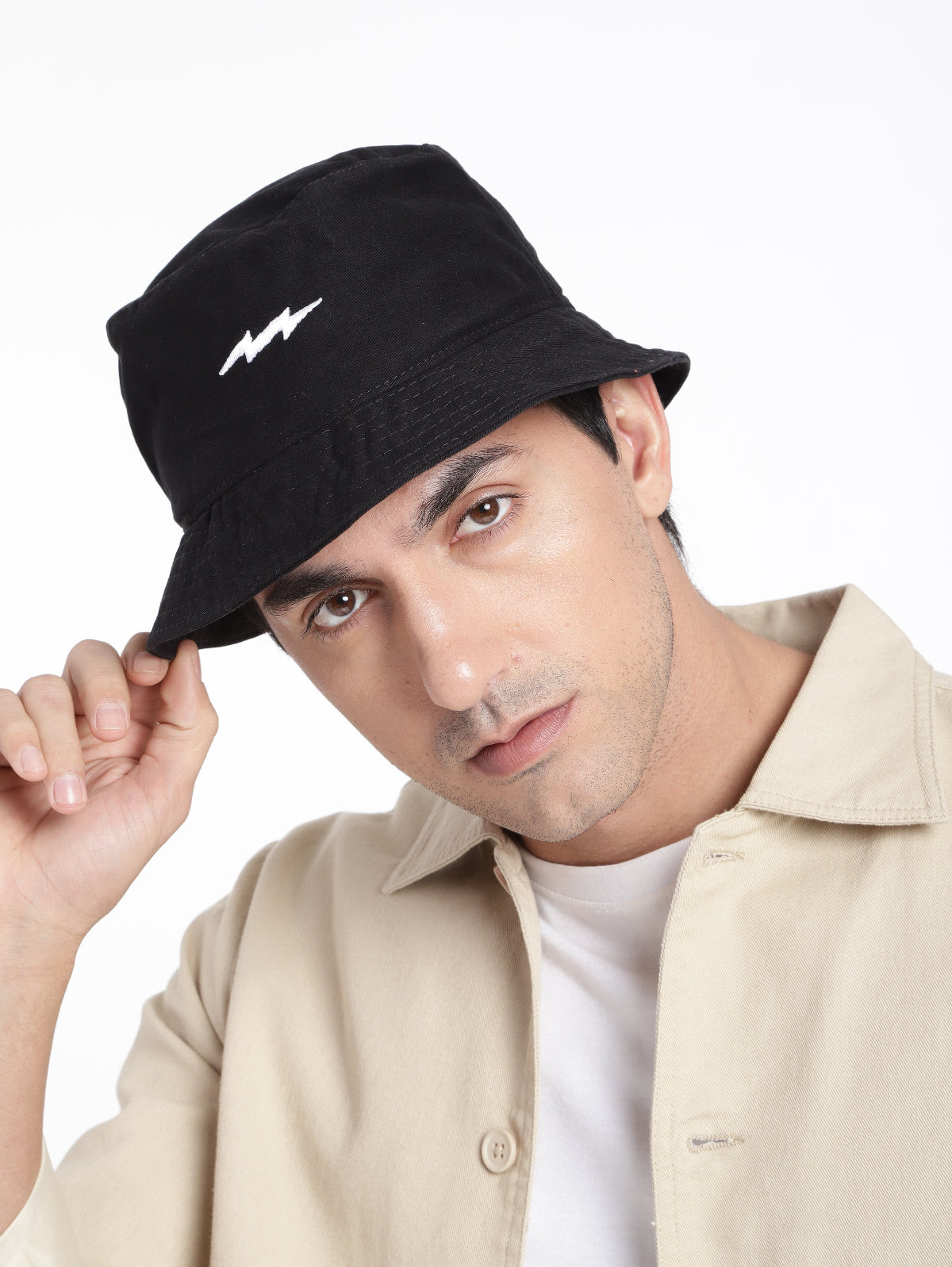 A person wearing a black bucket hat with a white lightning logo on the front.